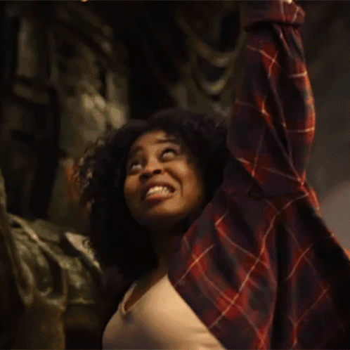 Woman In Plaid Shirt Raising Arms Smiling GIF