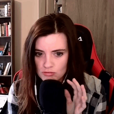 Woman in Plaid Shirt Sitting at Microphone With Letter A on Chair