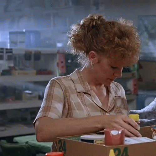 Woman in Plaid Shirt Sitting at Table With Box Number 24