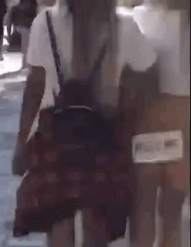 Woman In Plaid Skirt Walking With Backpack GIF