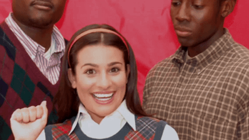 Woman in Plaid Vest Smiling With Two Men