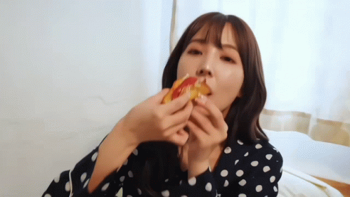 Woman in Polka Dot Shirt Eating Pizza