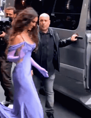 Woman in Purple Dress and Gloves Escorted