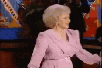 Woman in Purple Dress Dancing in Front of Crowd