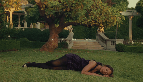 Woman in Purple Dress Lying on Grass by Tree Stairs