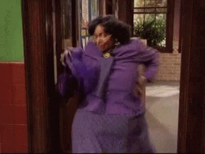 Woman In Purple Dress Standing By Door GIF