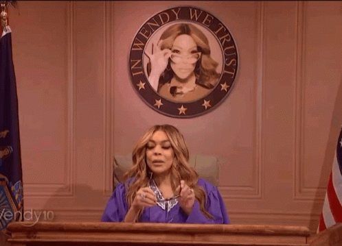 Woman in Purple Gown at Podium With Seal Saying In Wendy We Trust