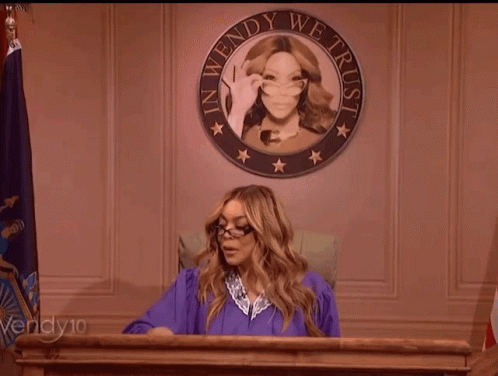 Woman In Purple Gown At Podium With Wendy We Trust Seal GIF