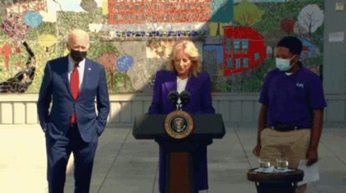 Woman In Purple Jacket At Podium With United States Of America Seal GIF