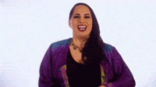 Woman In Purple Jacket Laughing And Holding Hair GIF