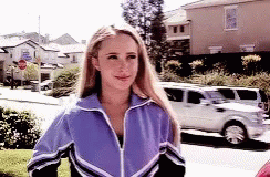 Woman In Purple Jacket Walking Down Street GIF