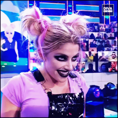 Woman in Purple Shirt and Black Overalls Smiling in Front of Diva Screen