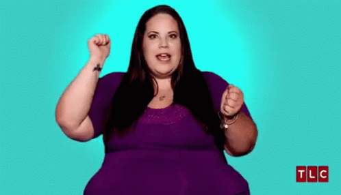 Woman in Purple Shirt Holding Fist Up