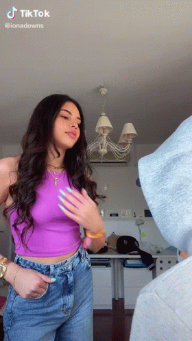 Woman In Purple Tank Top And Blue Jeans Standing In Room GIF