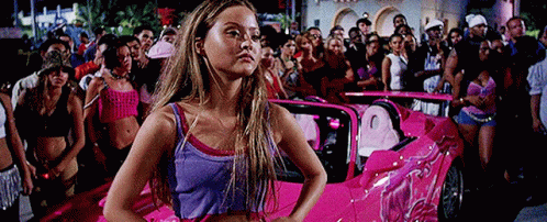 Woman in Purple Tank Top in Front of Pink Car
