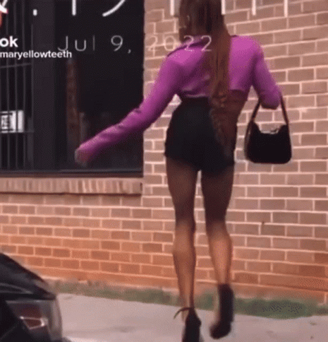 Woman in Purple Top and Black Shorts