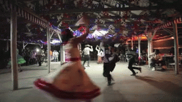 Woman in Red and White Dress Dancing in Crowd