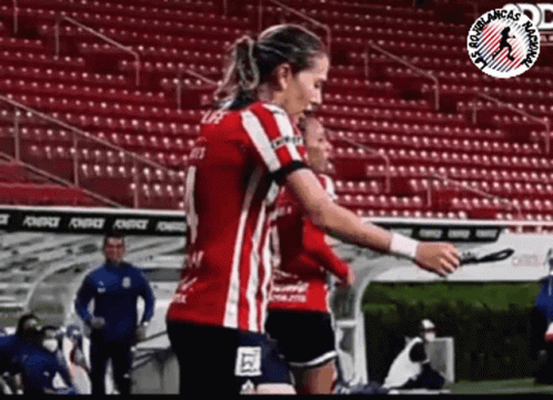 Woman in Red and White Striped Shirt on Soccer Field