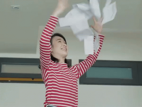 Woman in Red and White Striped Shirt Throwing Papers