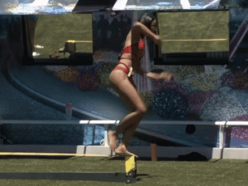 Woman in Red Bikini Jumping Over Yellow Barrier