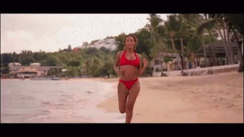 Woman in Red Bikini Running on Beach