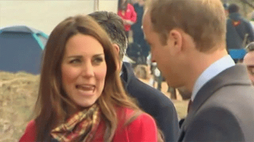 Woman In Red Coat And Scarf Next To Man GIF
