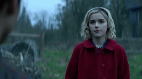 Woman in Red Coat Looking at Man in Field