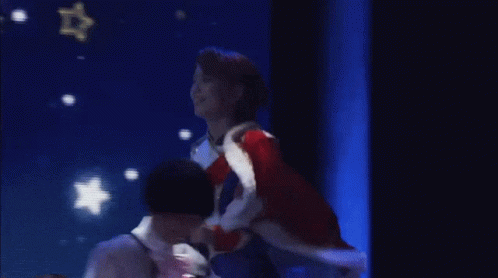 Woman In Red Coat On Stage With Blue Screen GIF