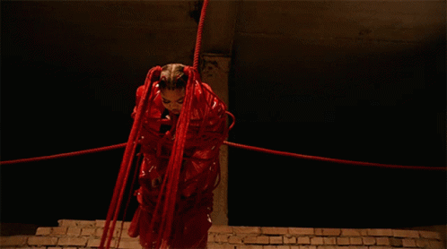 Woman in Red Costume Tied Up With Red Ropes