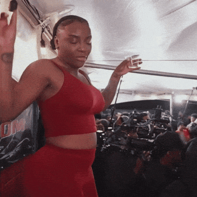Woman in Red Crop Top Dancing by DM Sign