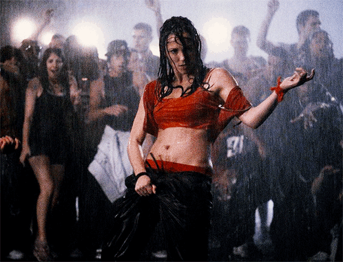 Woman in Red Dancing in Front of Crowd with Man in 27 Shirt