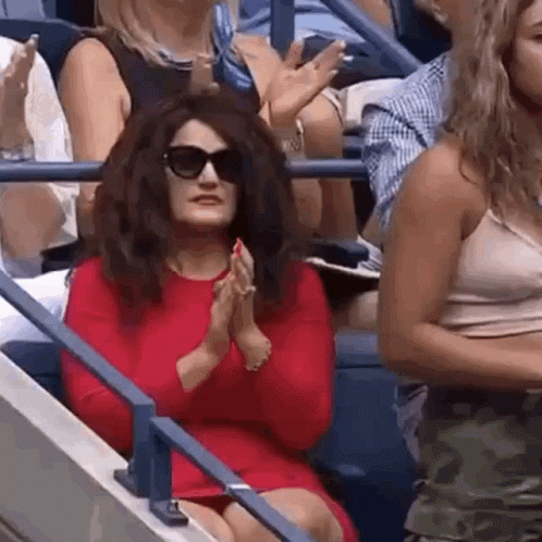 Woman in Red Dress and Sunglasses Clapping in Crowd