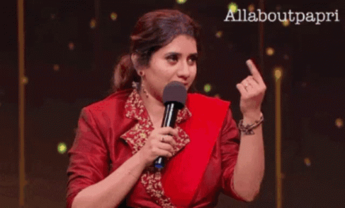 Woman in Red Dress Holding Microphone Giving Middle Finger