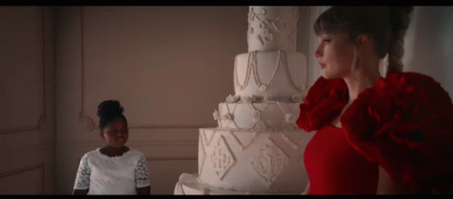 Woman in Red Dress in Front of Large White Cake