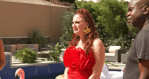 Woman in Red Dress Next to Man and Flamingo Float