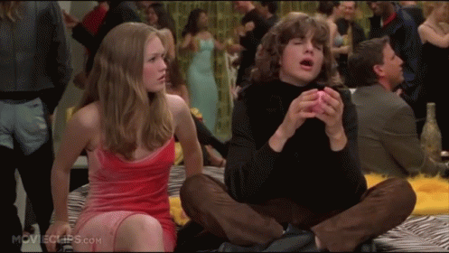 Woman in Red Dress Next to Man in Black Turtleneck Movie Scene