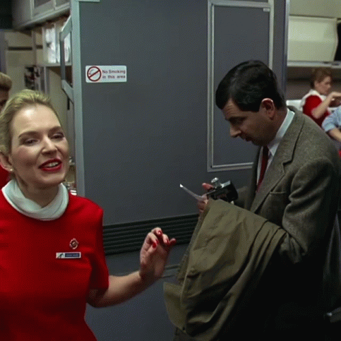 Woman In Red Dress Next To Man In Suit No Smoking Sign GIF