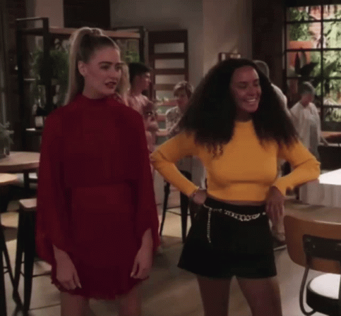 Woman in Red Dress Next to Woman in Yellow Shirt