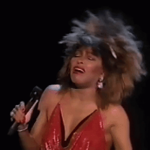 Woman In Red Dress Singing Into Microphone While Dancing GIF
