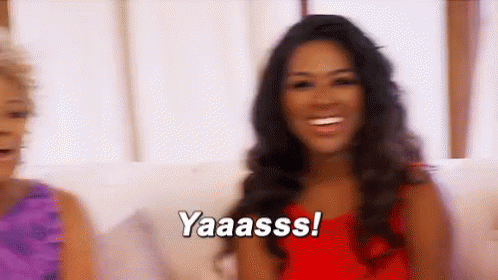 Woman In Red Dress Smiling While Another Says Yaaass GIF