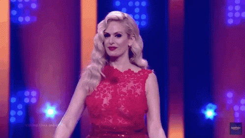 Woman in Red Dress Standing in Front of Stage
