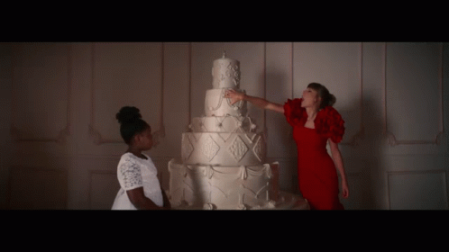 Woman in Red Dress Touching White Cake