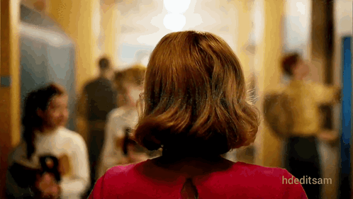 Woman in Red Dress Walking Down Hallway