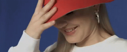 Woman In Red Hat Smiling Covering Face GIF