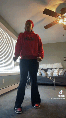 Woman in Red Hoodie Dancing in Living Room With Ceiling Fan