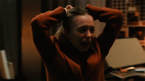 Woman in Red Jacket Holding Head in Hands