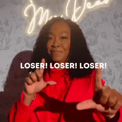 Woman in Red Jacket Making Loser Sign