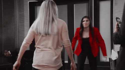 Woman in Red Jacket Next to Woman in Pink Shirt