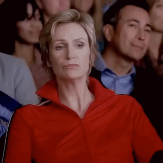 Woman in Red Jacket Sitting in Crowd