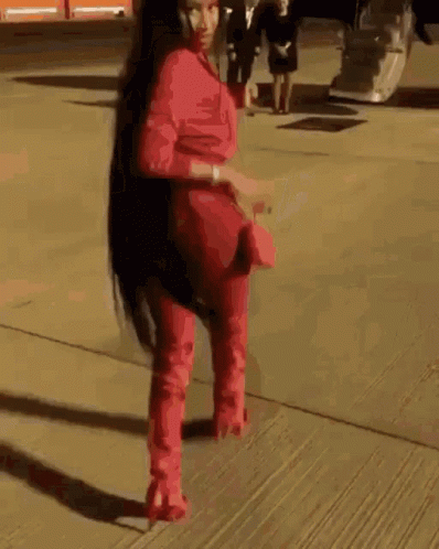Woman In Red Jumpsuit And Red Boots Walking GIF
